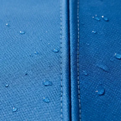 A detailed close-up showing the texture of Sunbrella acrylic fabric on a patio umbrella canopy, highlighting its weather-resistant properties. The image emphasizes the quality of the stitching and the vibrant, fade-resistant color.