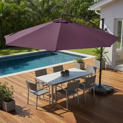 Purple Leaf cantilever patio umbrella providing shade over a modern outdoor dining area with comfortable seating.